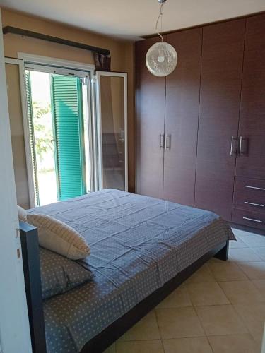 a bedroom with a large bed and a large window at Sunday Villa in Agios Georgios