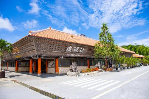 a building with an asian writing on the side of a street at オープンセール 2棟貸切 最大20名ビーチまで車で4分 駐車場4台 tla&tdy ツインズロッジA棟B棟貸切 in Yomitan