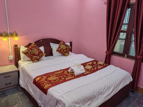 a bedroom with a bed with a teddy bear on it at ShuYa Hotel 舒雅酒店 in Luang Prabang