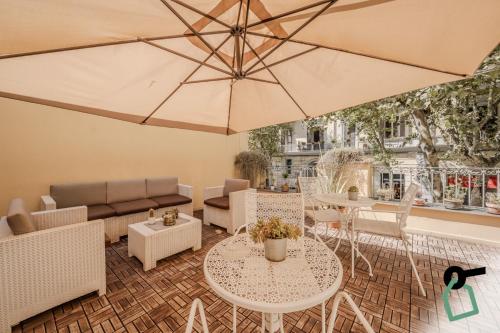 a patio with tables and chairs and an umbrella at Residenza Scarlatti Napoli in Naples