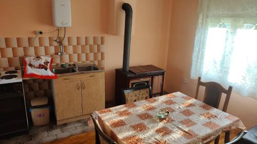 a kitchen with a stove and a table with a tableablish at Šumarev konak in Valjevo