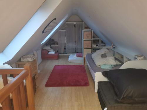 a attic room with a bed and a red rug at Villa individuelle 5 mn Lille centre Chr/eurasante in Haubourdin