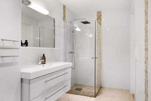 a white bathroom with a sink and a shower at En perle på Gjøvik, nær populær strand ved Mjøsa in Gjøvik