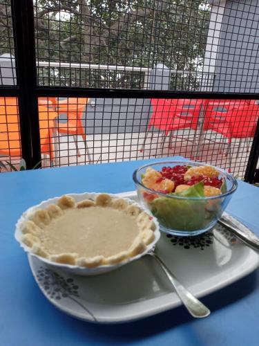 a pie and a bowl of fruit on a table at YOU and I CAFE in Varanasi