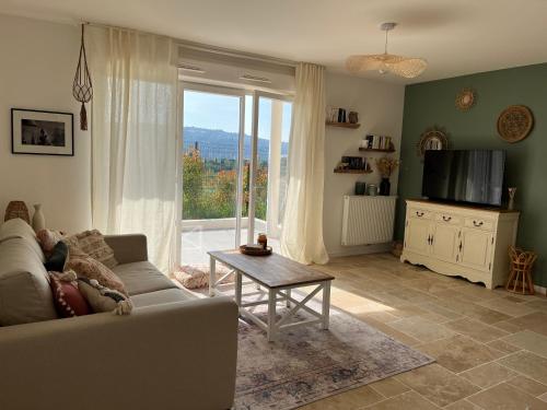un salon avec un canapé et une grande fenêtre dans l'établissement Superbe appartement lumineux en rez de jardin, à Saint-Laurent-du-Var