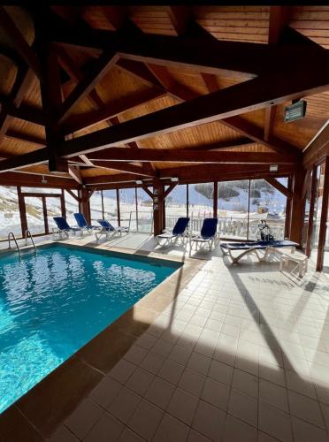 une piscine avec des chaises longues et une visière de piscine dans l'établissement Chez Virginie cocon familial, à Ustou