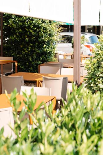 an outdoor cafe with tables and chairs and plants at Locanda Da I Baldi in Laveno