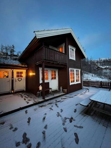 a group of birds walking around a house in the snow at Hytte i Målselv Fjellandsby in Bergset