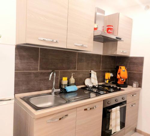 una cucina con lavandino e piano cottura di Murriali Apartment a Monreale