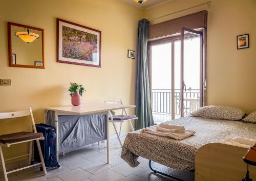 a bedroom with a bed and a desk and a window at Collina del Sole in Letojanni