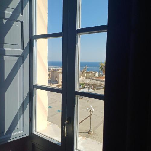 an open window with a view of the ocean from a building at Palazzo Boyl 1840 in Cagliari