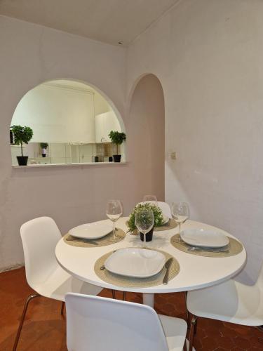 une salle à manger blanche avec une table et des chaises blanches dans l'établissement Sublime appartement 4P classé dans le Vieux-Nice, à Nice