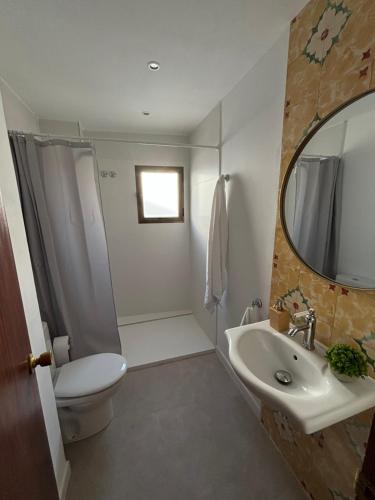a bathroom with a sink and a toilet and a mirror at Cal Ferrer in Benimeli