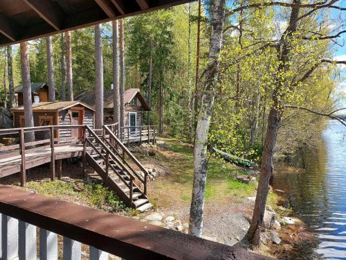a log cabin in the woods next to the water at Koivurannan lomamökit Kotkanpesä in Mikkeli