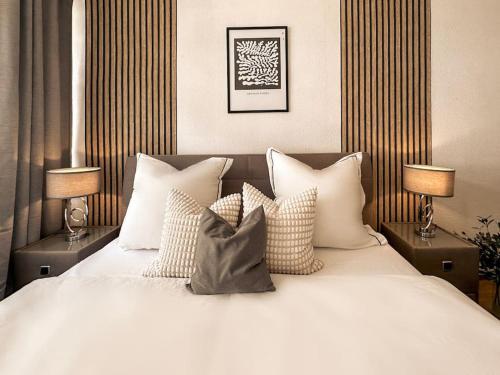 a bedroom with a white bed with pillows and two lamps at Modern eingerichtete Wohnung im Stadtzentrum Zittau kostenloser Parkplatz in Zittau