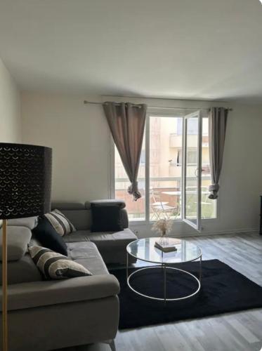 un salon avec un canapé et une table en verre dans l'établissement Appartement 85m2 La Défense,Balcony, à Courbevoie