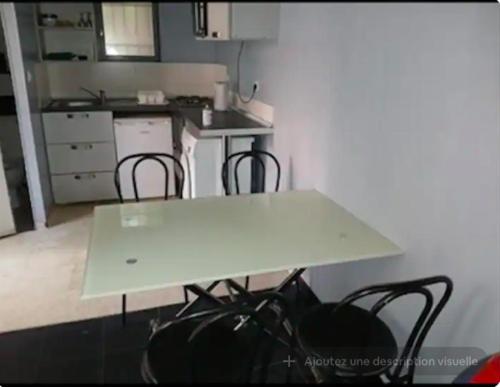 une table blanche et des chaises dans une cuisine dans l'établissement appartement proche du stade 2, à Marseille