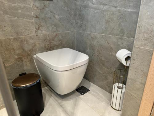 a bathroom with a toilet and a trash can at Diamond Serenity Villa in Kardamaina