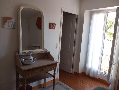 La salle de bains est pourvue d'un miroir et d'une table en bois avec lavabo. dans l'établissement Maison mer plage du débarquement Caen Nord, à Bernières-sur-Mer