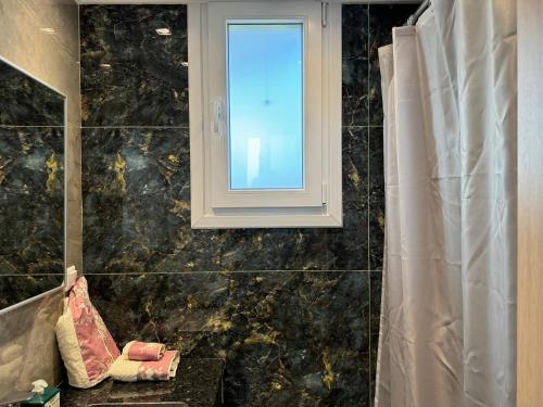 a bathroom with a window and a bath tub at Diamond Serenity Villa in Kardamaina