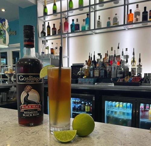 a bottle of whiskey and a drink on a bar at Hotel Collingwood BW Signature Collection in Bournemouth