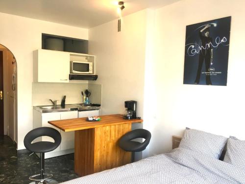 Cette chambre comprend un lit et une table avec deux chaises. dans l'établissement Cannes center terrace AC Wifi 200 m from sea behind Martinez, à Cannes