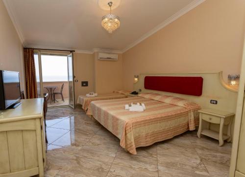 a hotel room with two beds and a television at Hotel Terrazzo Sul Mare in Tropea