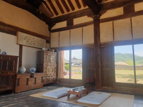 a room with a large window and a table in a building at Hahoe Chunghyodang in Andong