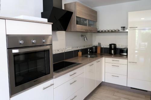 a kitchen with white cabinets and stainless steel appliances at Art Villa Malija in Portorož