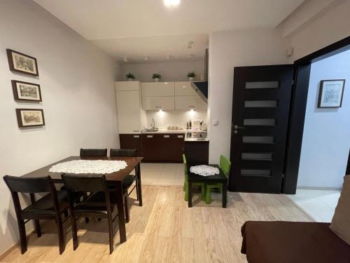 a dining room with a table and chairs and a kitchen at Mieszkanie Serce Natury w Polanicy Zdrój in Polanica-Zdrój