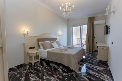 a bedroom with a large bed and a chandelier at Hotel Terrazzo Sul Mare in Tropea