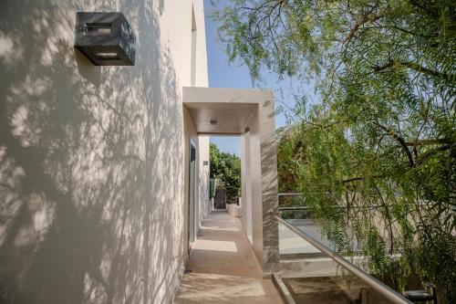 a hallway leading up to a building with trees at Harmony Villa in Schinias