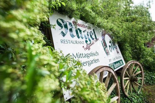 a sign for a restaurant with a wagon at Hotel & Gasthaus Nagel GmbH in Südlohn