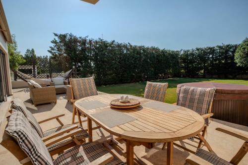 a wooden table and chairs on a patio at Harmony Villa in Schinias