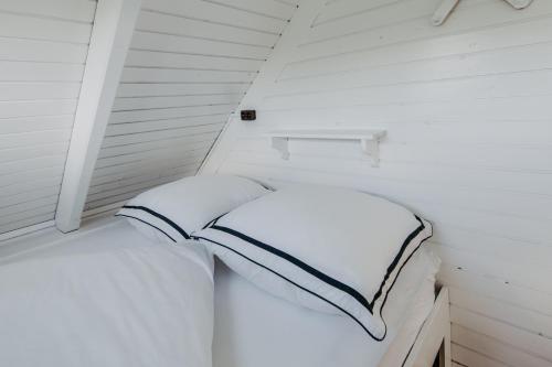 a bed in a small room with white walls at Seehütte Neusiedlersee - Seehaus inklusive Elektroboot in Rust