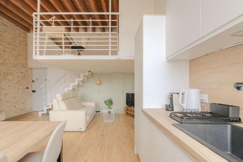 Il comprend une cuisine et un salon avec un escalier en colimaçon. dans l'établissement Moderne et authentique T2, proche Croix-Rousse, à Caluire-et-Cuire