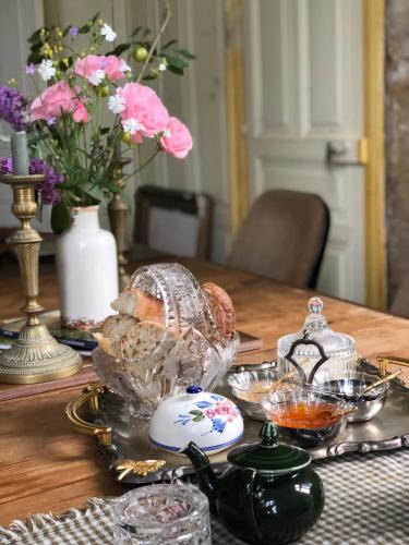 une table avec une assiette de nourriture et de fleurs dans l'établissement Château de Sainte-Sévère, à Sainte-Sévère-sur-Indre