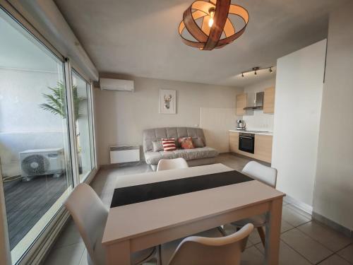 une cuisine et un salon avec une table et des chaises dans l'établissement Appartement T2 les Capucines, à La Ciotat