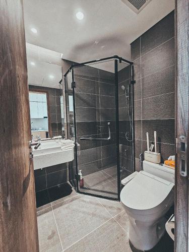 a bathroom with a shower and a toilet and a sink at Onsen Landmark Ecopark in Cong Luận