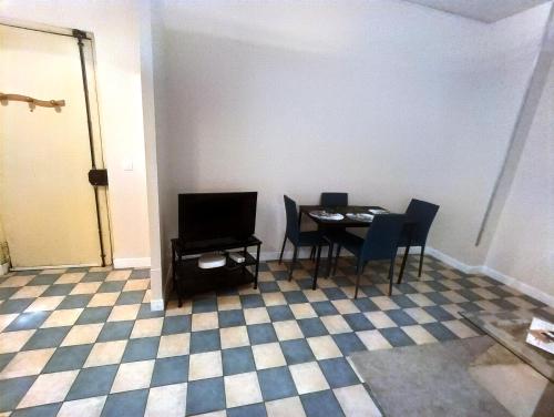 une salle à manger avec une table, des chaises et une télévision dans l'établissement Simplicité et confort, à Saint-Fons