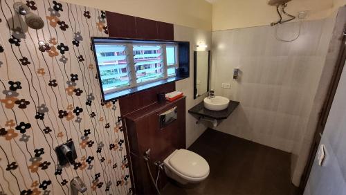 a bathroom with a toilet and a sink and a window at Heritage Exotica Villa 3BHK JAQK Holidays in Arpora