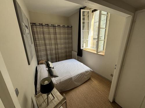 a small bedroom with a bed and a window at Apartment in downtown Bordeaux in Bordeaux