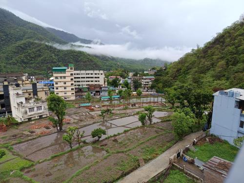 a view of a city with a mountain at Welcome Home Stay & Hotel Tapovan Rishikesh in Rishīkesh