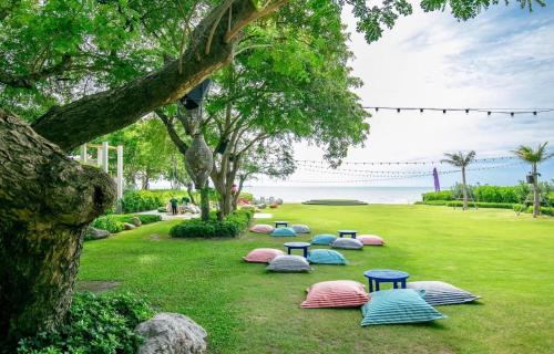 a row of picnic tables in the grass near the water at Blue condo Thew Talay seaview By Bigbike in Cha Am