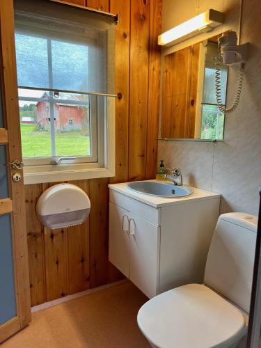 a bathroom with a sink and a toilet and a window at Gullvåg Camping Nyberg in Soknedal
