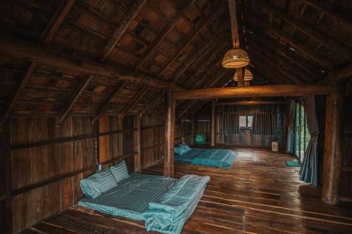 a room with two beds in a wooden cabin at Dancasa Horse Farm & Homestay in Buôn Chiêt