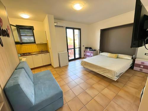 a bedroom with a bed and a couch and a tv at Marchetti Home in Pantelleria