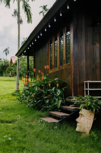 a small building with a bunch of flowers next to it at Dancasa Horse Farm & Homestay in Buôn Chiêt
