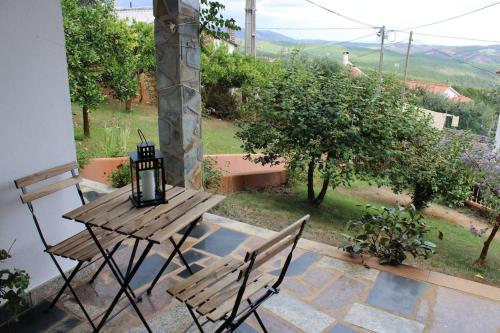 a wooden table and two chairs on a patio at Apalaches Trail House in Oleiros