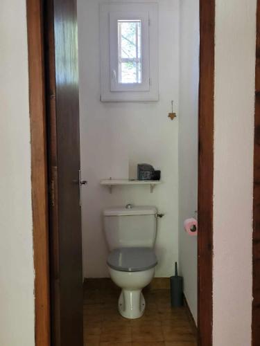 a white toilet in a bathroom with a window at Borie en Provence in Velleron